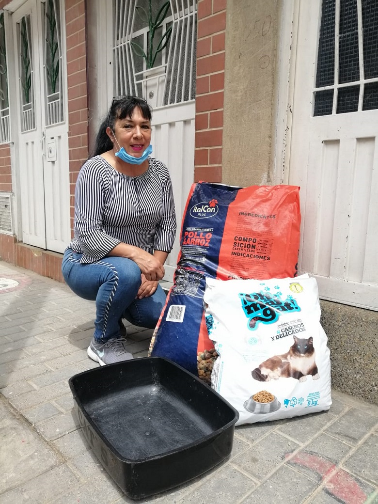 Señora con dos bultos de comida para animales