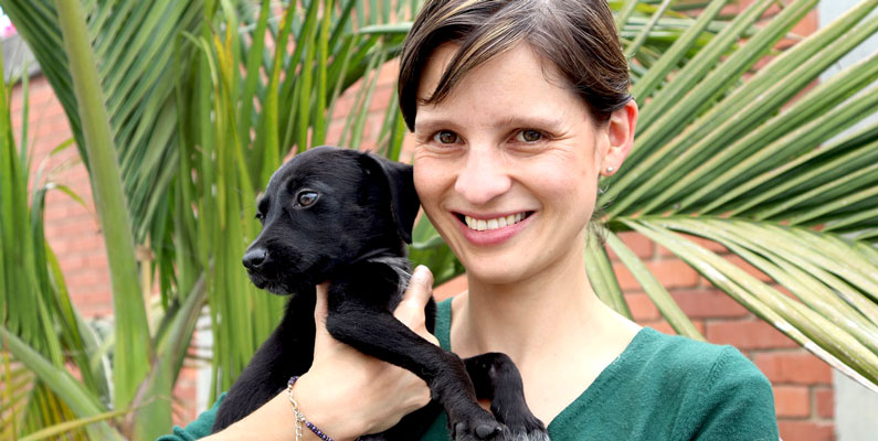 Adnrea Padilla alzando un cachorro