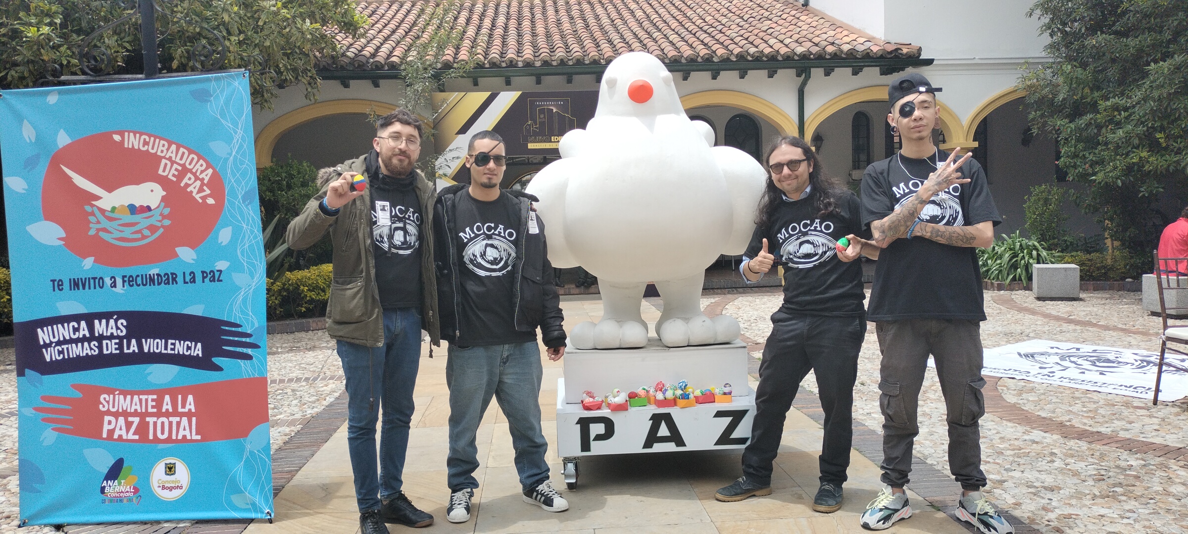 imagen de cuatro personas alrededor de una escultura de una paloma. están en la plazoleta interna del concejo de Bogotá