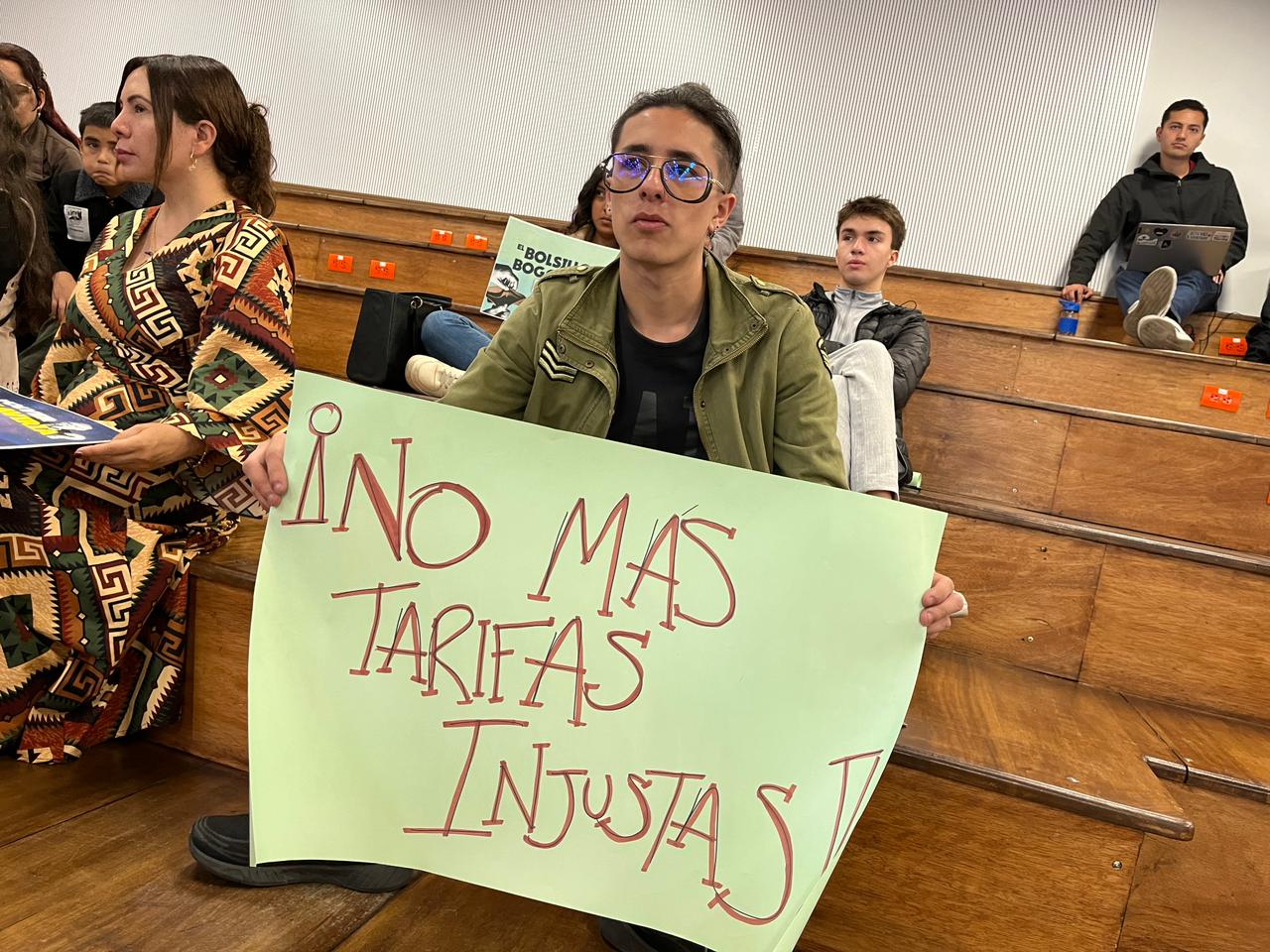 Ciudadano con un cartel que dice "no más tarifas injustas"