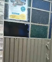 Fotografía en la que aparece una puerta con un vidrio roto