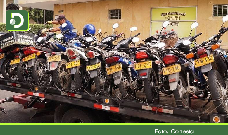 Fotografía de una grua de planchón con varias motocicletas sobre ella
