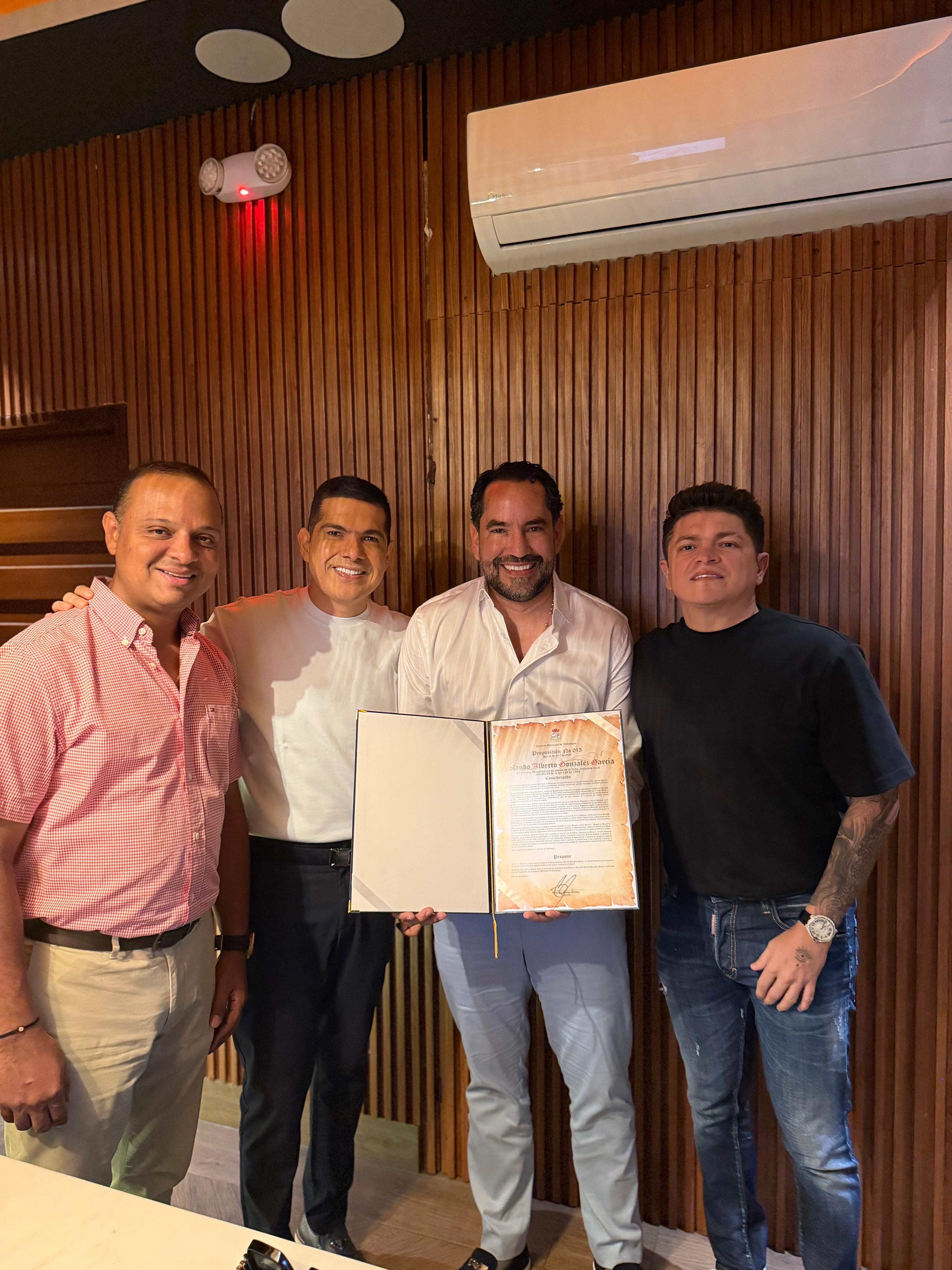 En esta foto el H.C. Rolando Gonzalez sosteniendo pergamino junto al cantante Peter Manjarrés y otros dos hombres